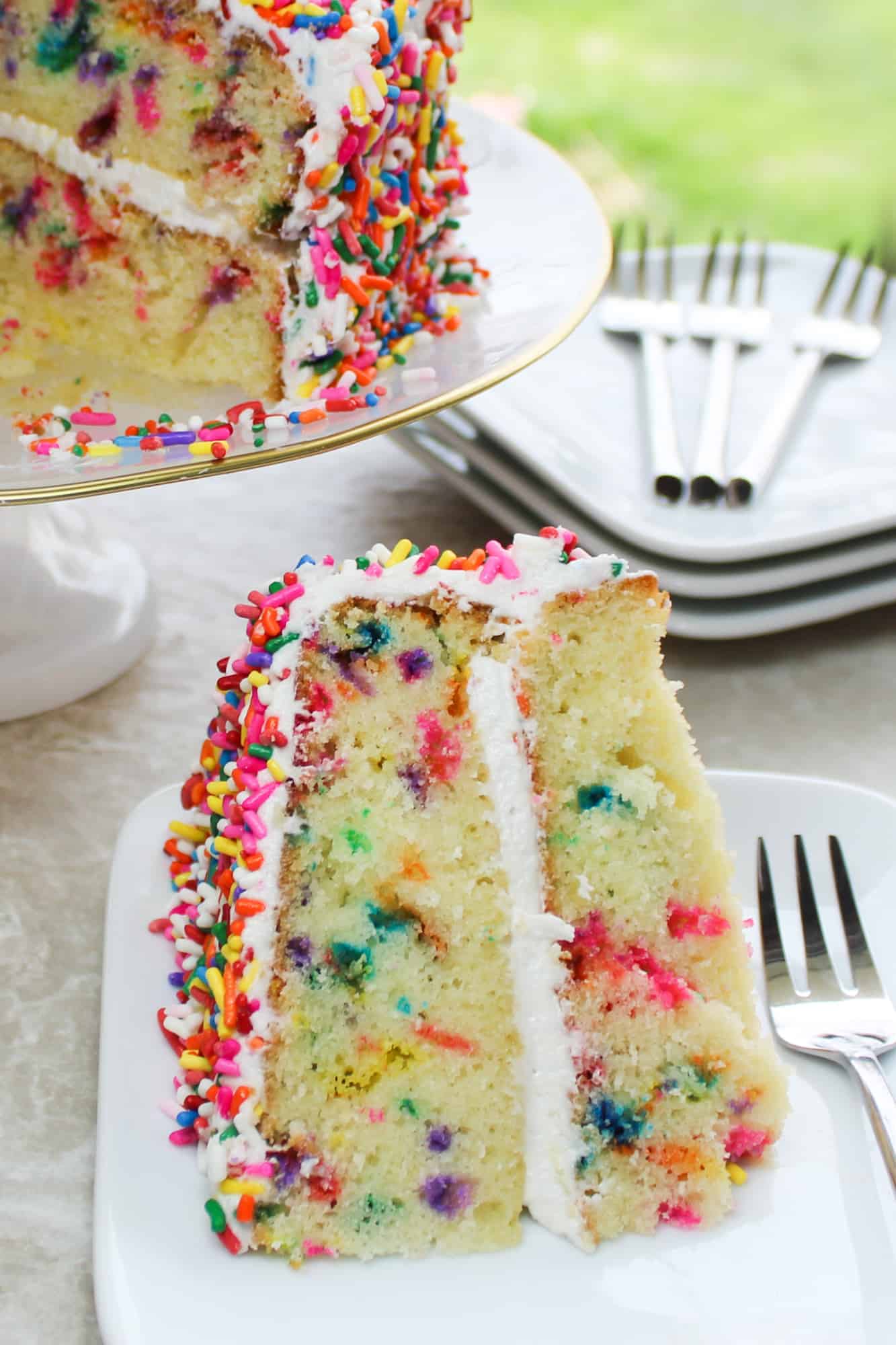 rainbow sprinkle cake on a plate with a fork