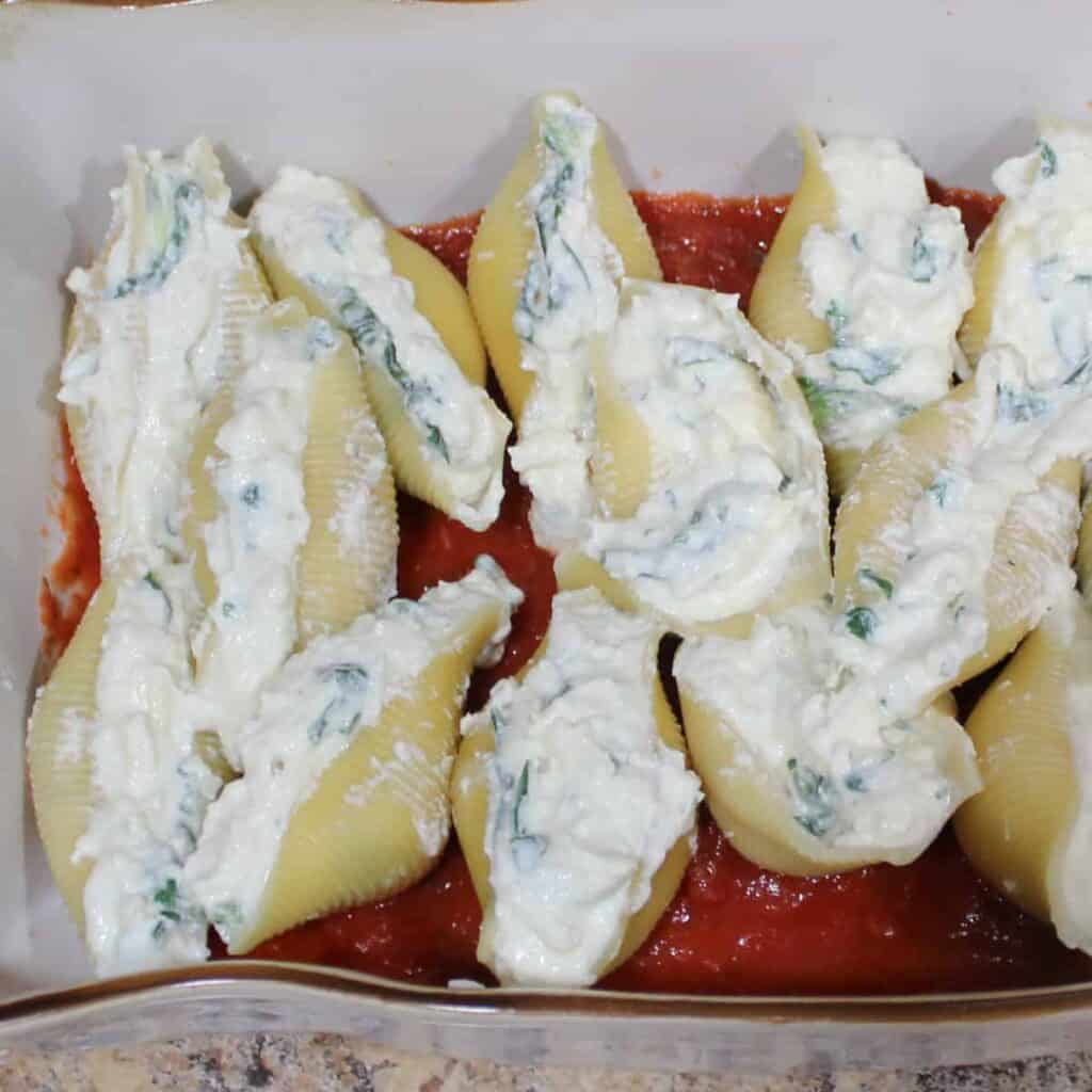 stuffed shells in a pan on top of sauce