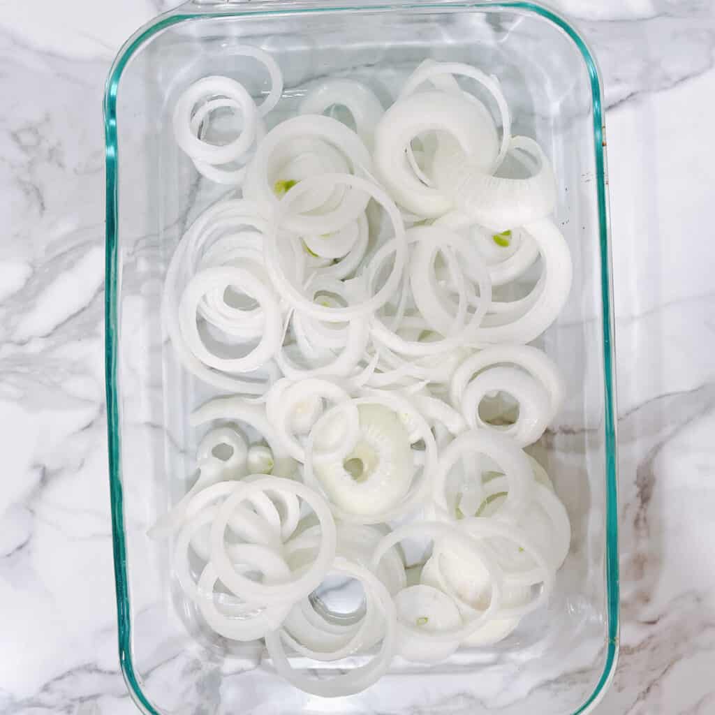 line baking dish with sliced onion