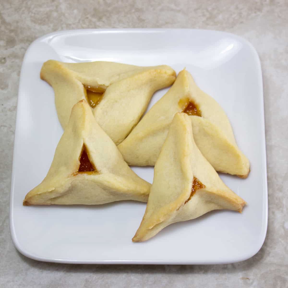 easy hamantaschen recipe filled with apricot jam on a plate