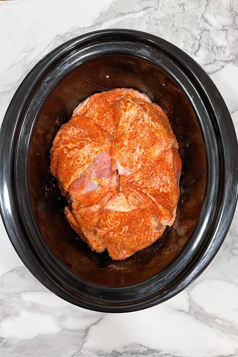 slow cooker bbq chicken thighs coated with spice blend